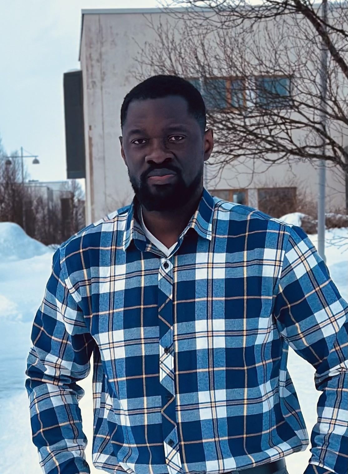Bright Appia Adu-Gyamfi cr.jpg Norges første doktor i luffart, Bright Appiah Adu-Gyamfi, ved UiT Norges arktiske universitet. Mann i rutete skjorte utendørs i Tromsø, snø i bakgrunnene.